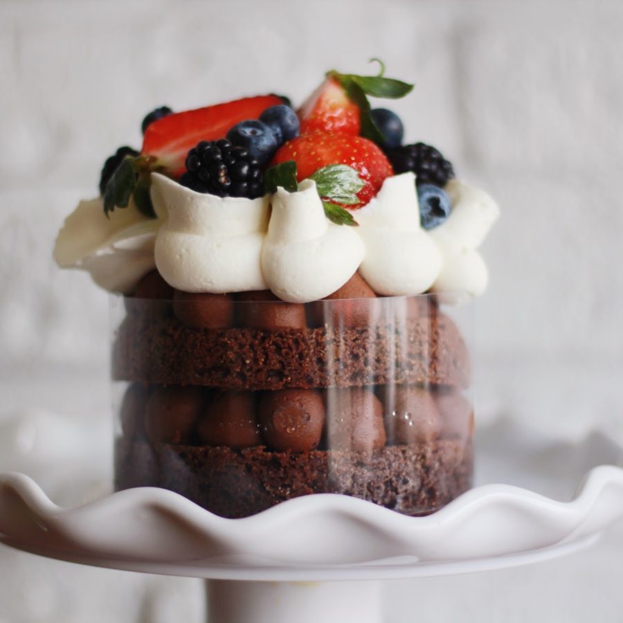 Postre individual de chocolate con crema y frutos rojos